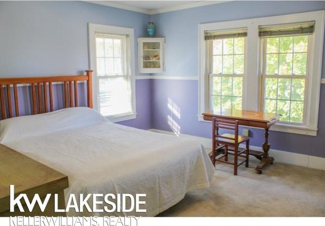 bedroom with multiple windows, ornamental molding, and carpet