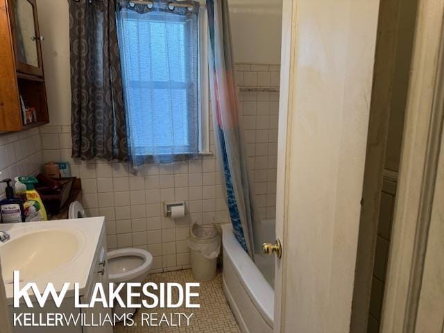 full bathroom with vanity, tile walls, and shower / bath combo