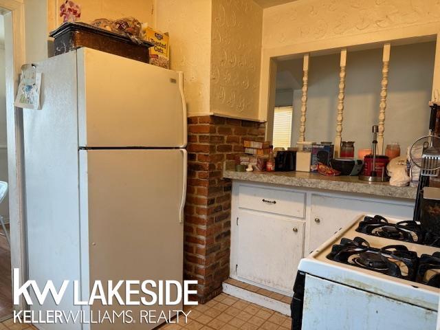 kitchen with white cabinetry and white appliances