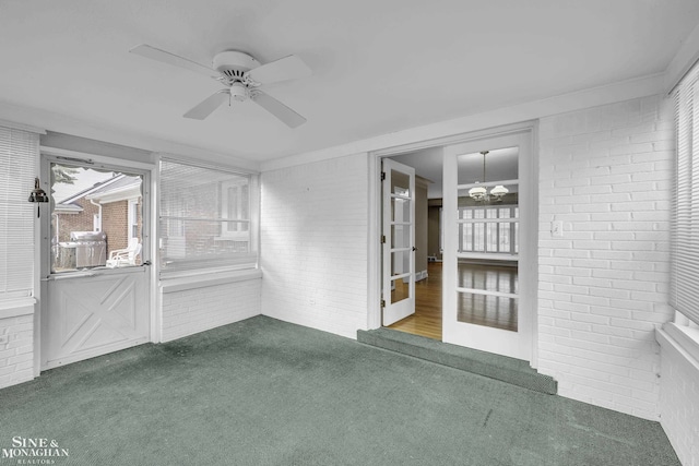 unfurnished sunroom with ceiling fan with notable chandelier