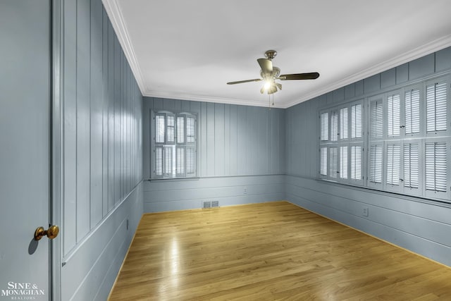 empty room with ceiling fan, ornamental molding, and light hardwood / wood-style floors