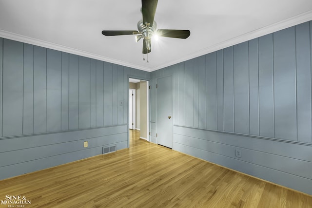 empty room with crown molding, light hardwood / wood-style floors, and ceiling fan