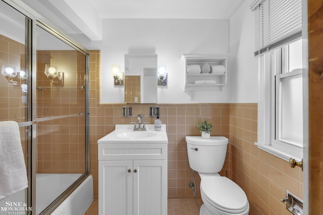 full bathroom featuring tile walls, vanity, enclosed tub / shower combo, and toilet