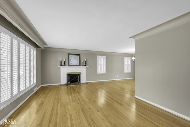 unfurnished living room with ornamental molding and light hardwood / wood-style floors