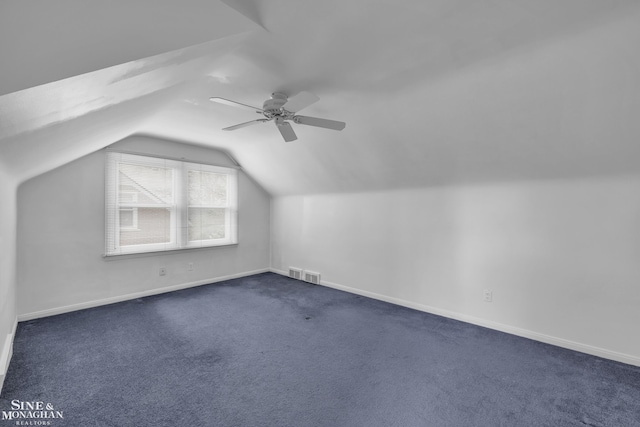 bonus room featuring dark colored carpet, vaulted ceiling, and ceiling fan