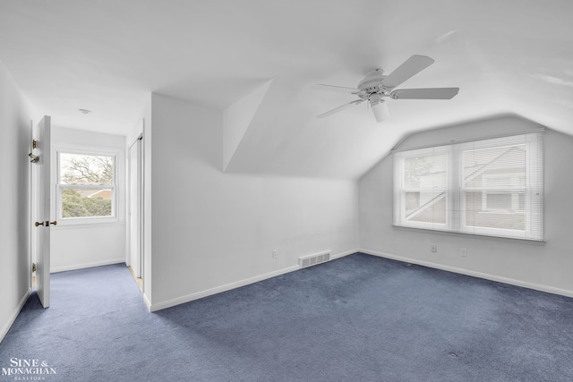 additional living space with vaulted ceiling, ceiling fan, and dark colored carpet