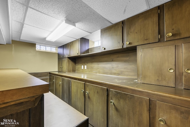 kitchen featuring tasteful backsplash and a drop ceiling