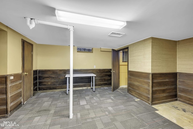 basement with carpet floors and wood walls