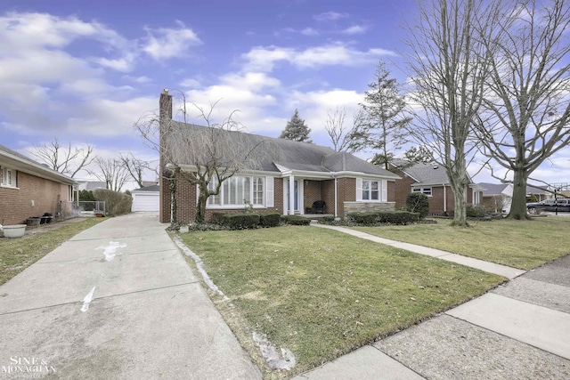 ranch-style house featuring a garage, an outbuilding, and a front lawn