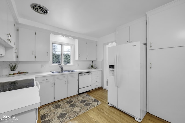 kitchen featuring sink, white appliances, light hardwood / wood-style flooring, and white cabinets