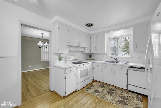 kitchen featuring sink, white cabinets, white appliances, and decorative light fixtures