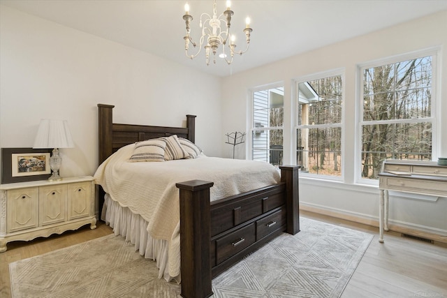 bedroom with a notable chandelier and light hardwood / wood-style floors