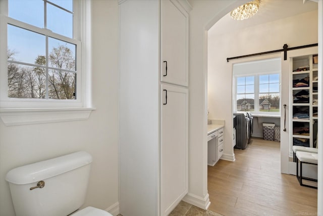 bathroom featuring vanity, a notable chandelier, hardwood / wood-style flooring, and toilet