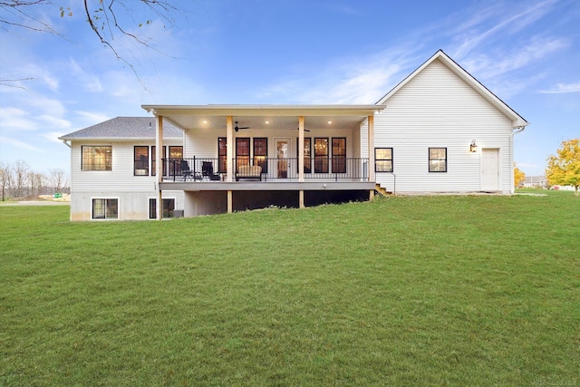 rear view of house featuring ceiling fan and a lawn