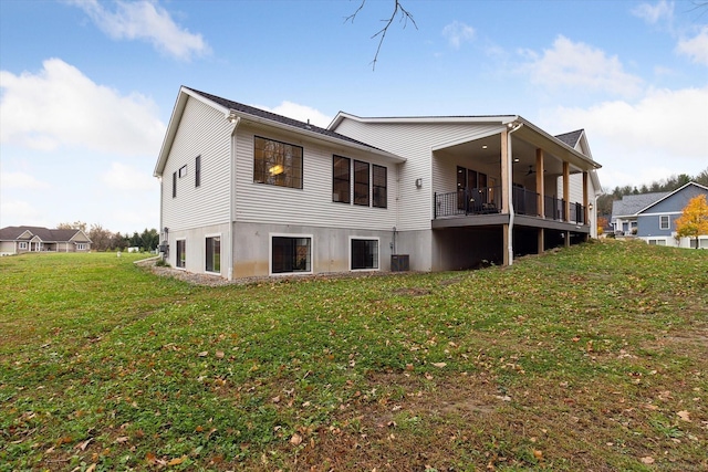 back of property featuring a yard and ceiling fan