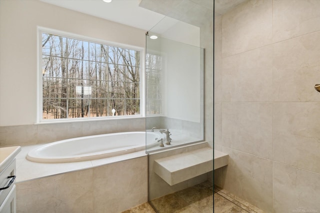 bathroom featuring vanity and tiled bath