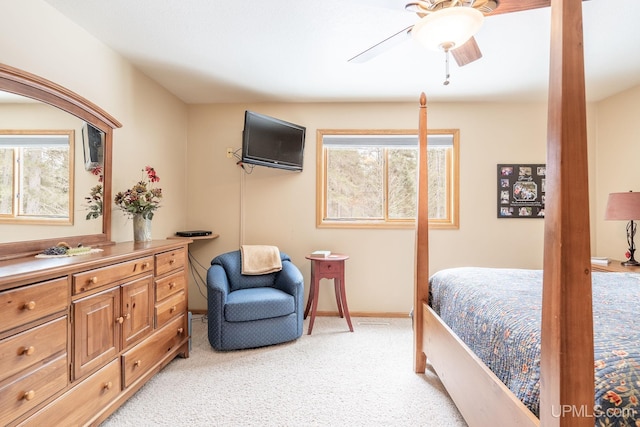 bedroom featuring ceiling fan, multiple windows, and light carpet