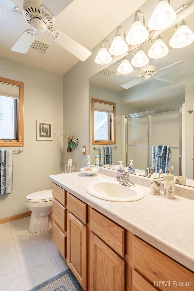 bathroom featuring vanity, walk in shower, ceiling fan, toilet, and tile patterned floors