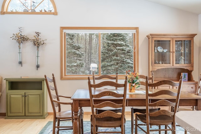 dining space featuring lofted ceiling and light wood-type flooring