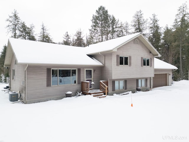 tri-level home featuring central AC and a garage