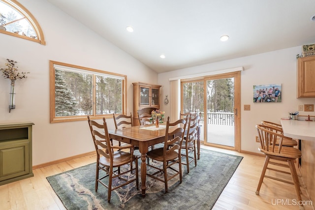 dining room with lofted ceiling and light hardwood / wood-style floors