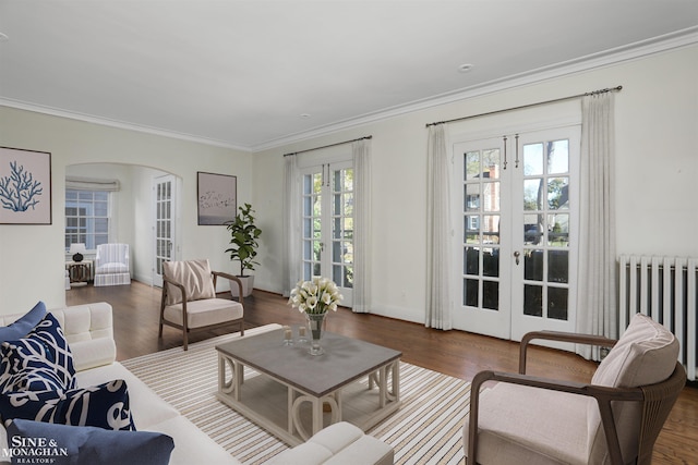 living room with french doors, radiator heating unit, crown molding, and dark wood-type flooring