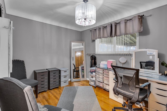 office space featuring a notable chandelier and light wood-type flooring