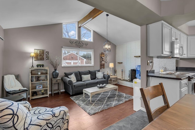 living room featuring dark hardwood / wood-style floors, vaulted ceiling with beams, and a notable chandelier