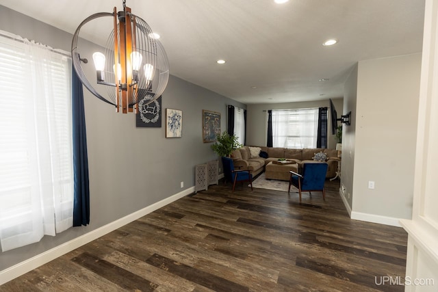 living area featuring dark hardwood / wood-style floors and an inviting chandelier