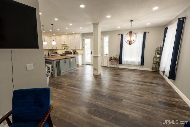 interior space with ornate columns, dark wood-type flooring, and sink