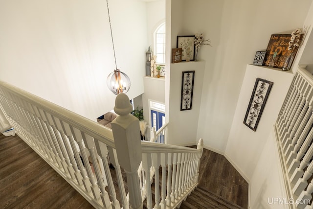 staircase featuring hardwood / wood-style floors and a notable chandelier