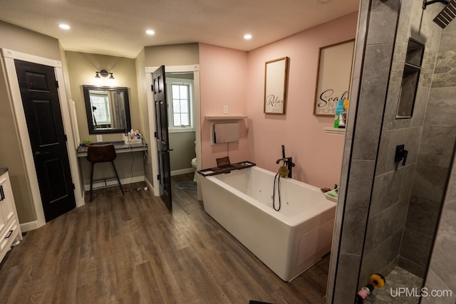 full bathroom with vanity, hardwood / wood-style floors, independent shower and bath, and toilet