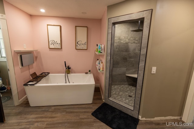 bathroom featuring shower with separate bathtub and hardwood / wood-style floors