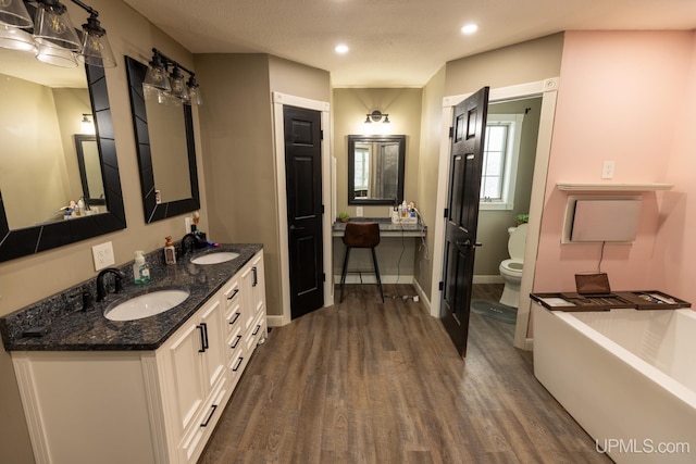 bathroom with hardwood / wood-style flooring, vanity, and toilet