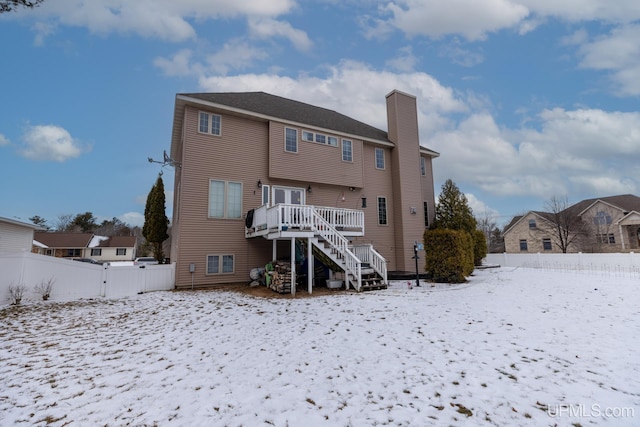 snow covered property with a wooden deck