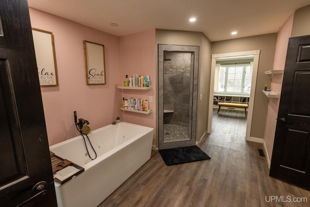 bathroom featuring wood-type flooring and independent shower and bath