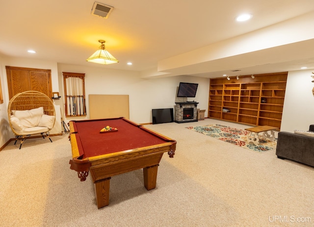 rec room with a stone fireplace, pool table, and carpet