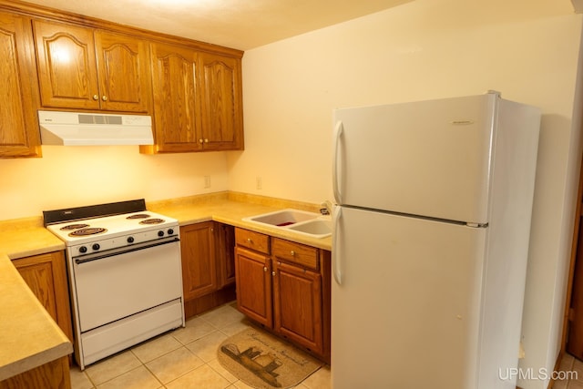 kitchen with sink, light tile patterned floors, and white appliances