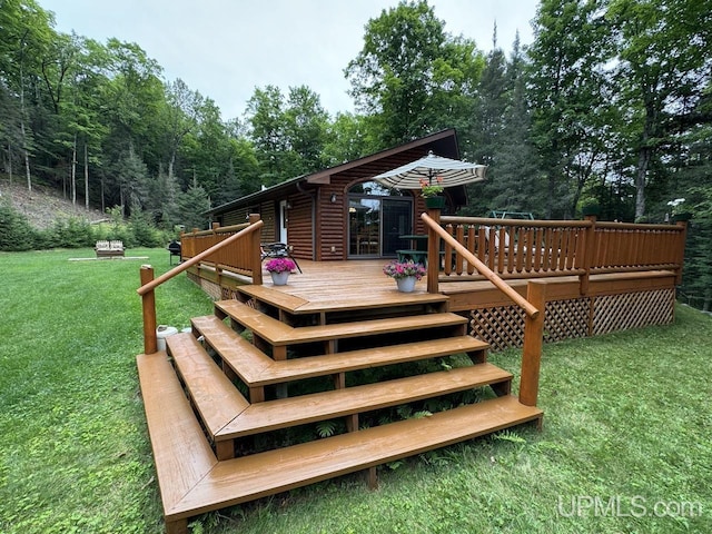 wooden deck featuring a lawn