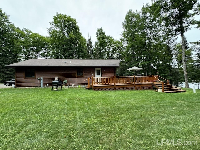 back of house featuring a wooden deck and a yard