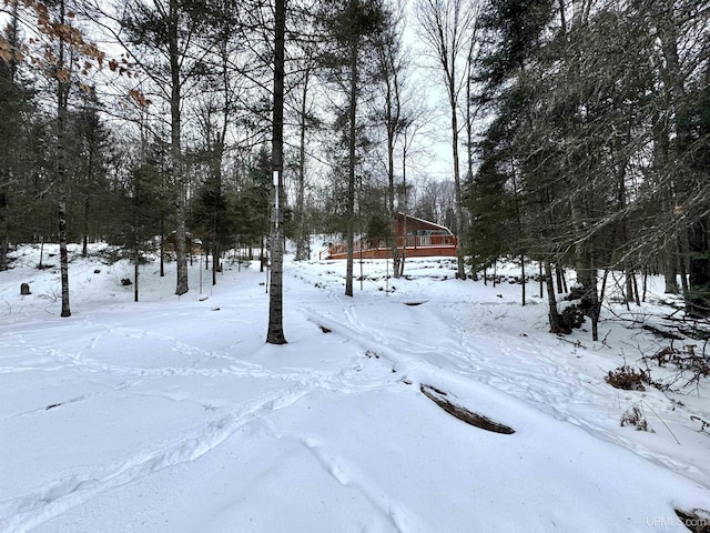 snowy yard featuring a wooden deck