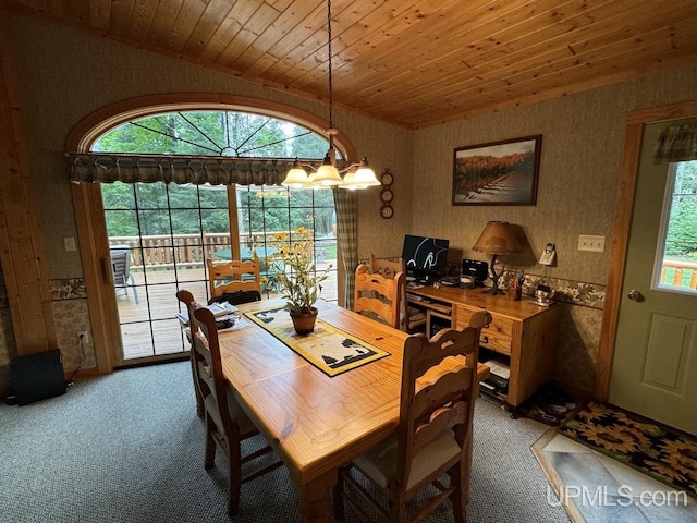 carpeted dining room featuring lofted ceiling, a notable chandelier, wood ceiling, and a healthy amount of sunlight