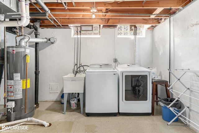 laundry room with gas water heater and washer and dryer