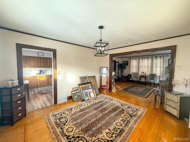 dining room featuring crown molding, a notable chandelier, and light hardwood / wood-style floors