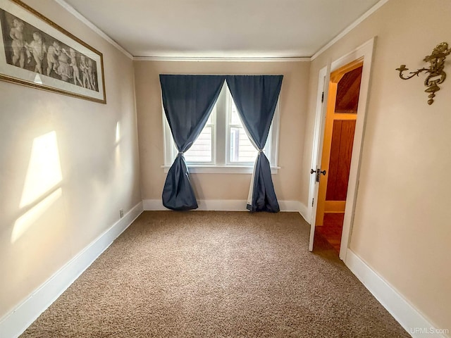 carpeted spare room featuring crown molding