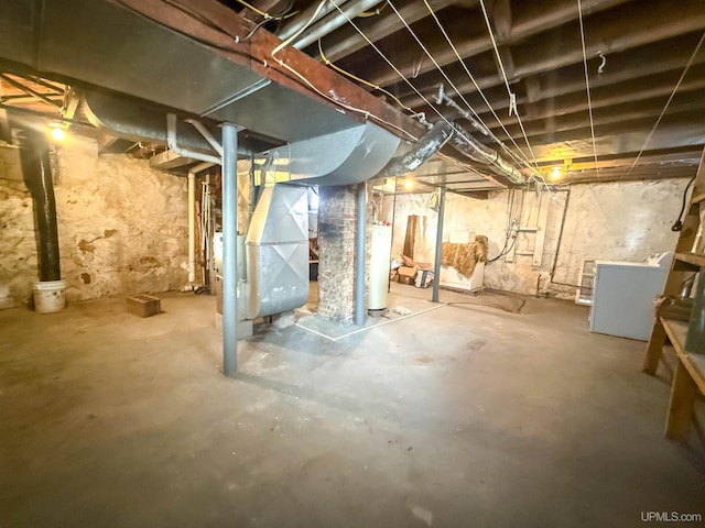 basement featuring heating unit, washer / dryer, and water heater