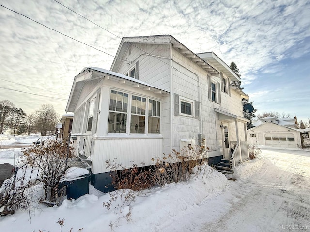 snow covered property with a garage