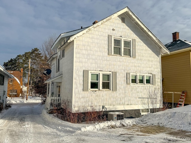 snow covered property featuring central air condition unit