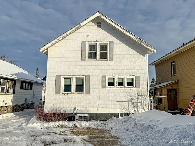 snow covered property with central air condition unit