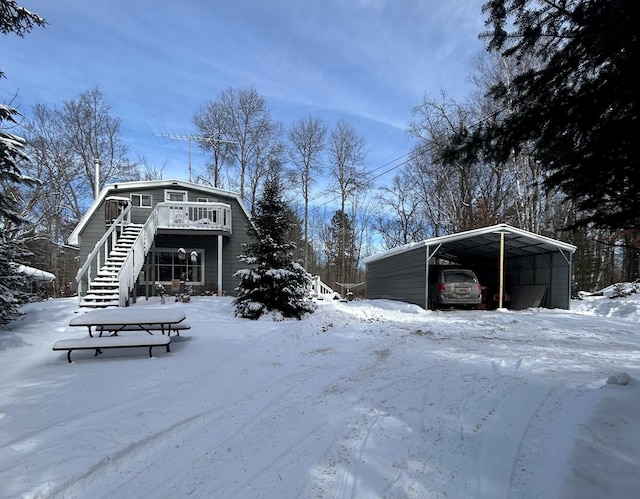 view of snow covered exterior with a wooden deck and a carport